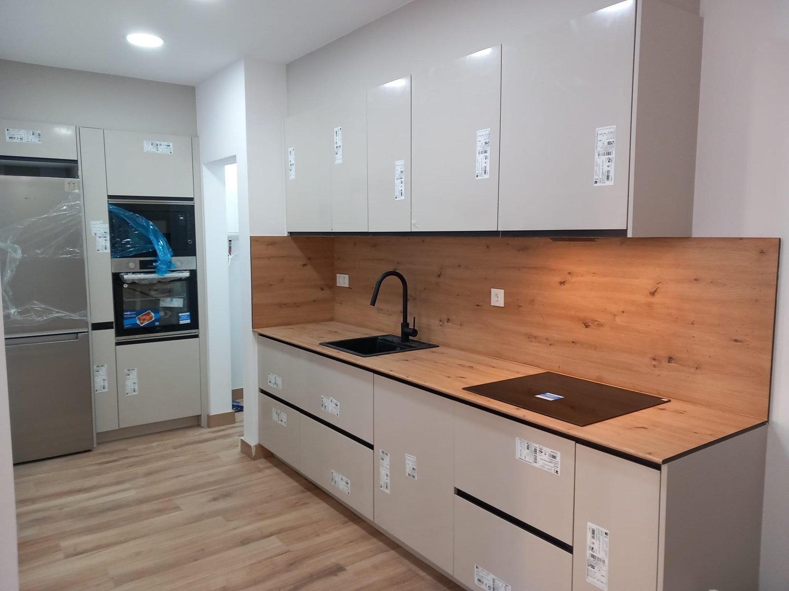 Cocina crema sin tiradores con frente de madera natural