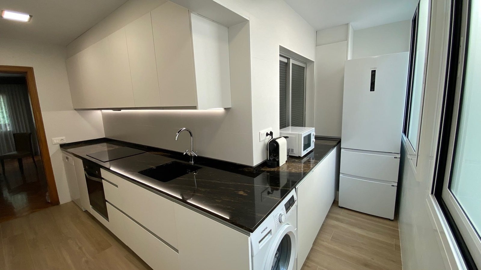Cocina blanca con encimera de granito negro