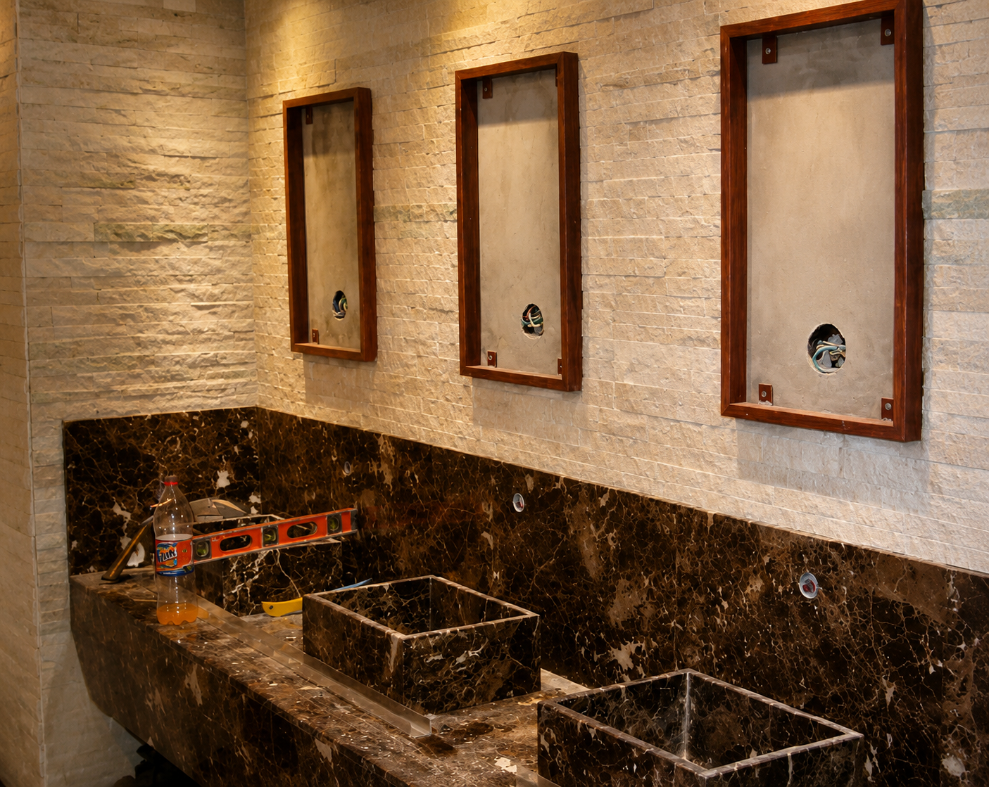 Aseo de local con encimera de piedra natural y revestimiento claro