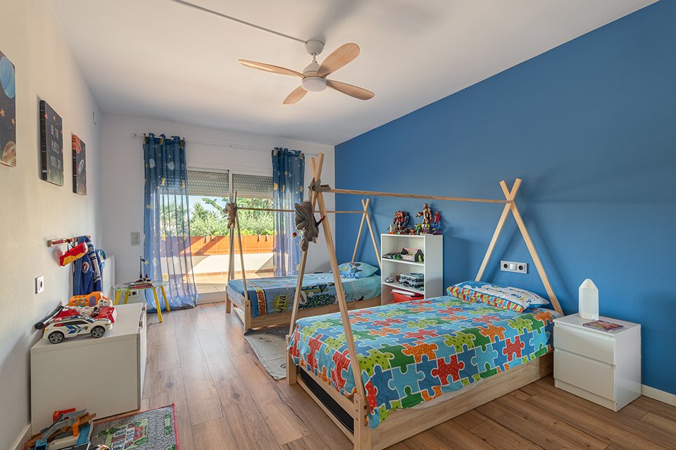 Habitación infantil con camas tipi y pared azul