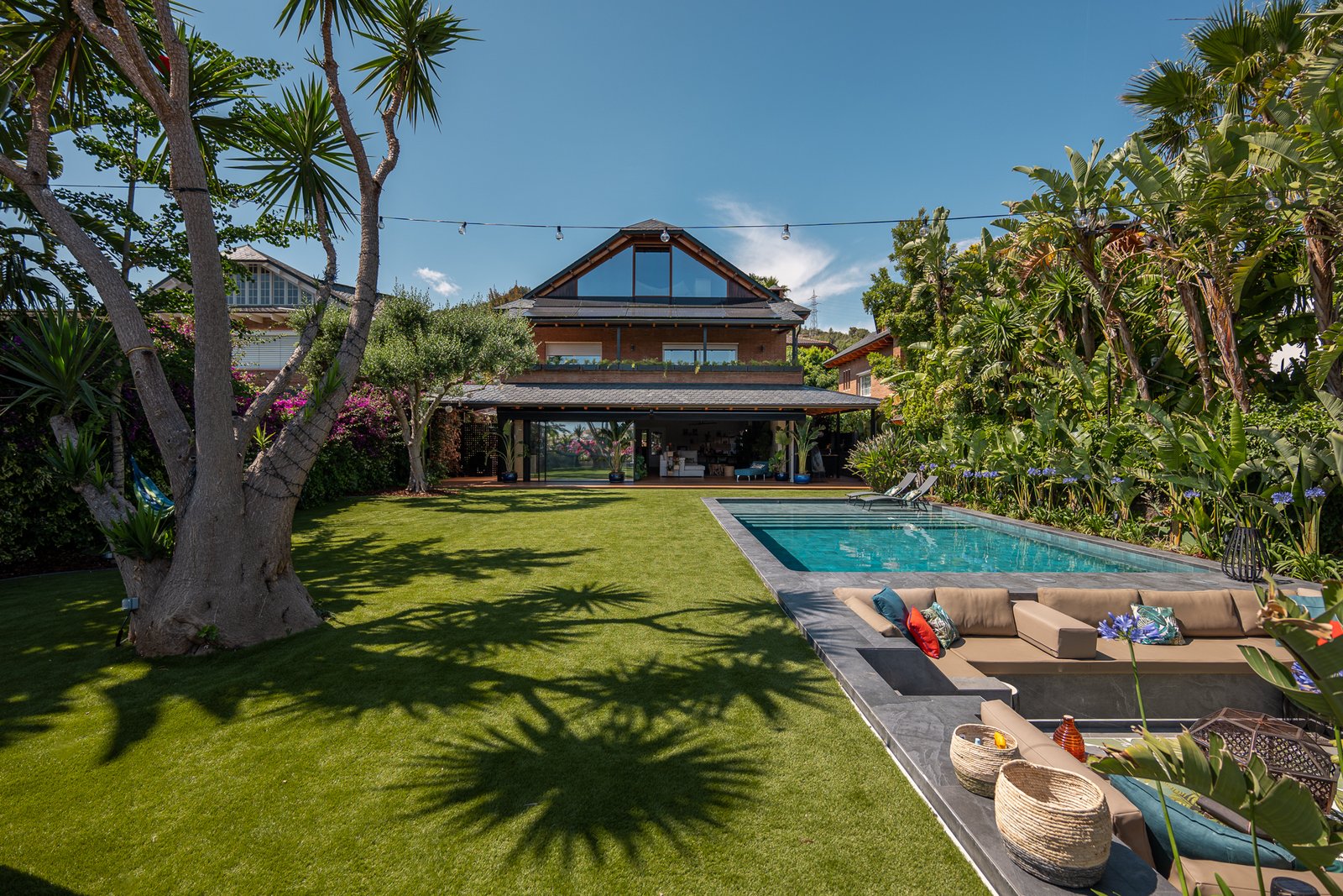 Jardín con césped, piscina y zona lounge de día