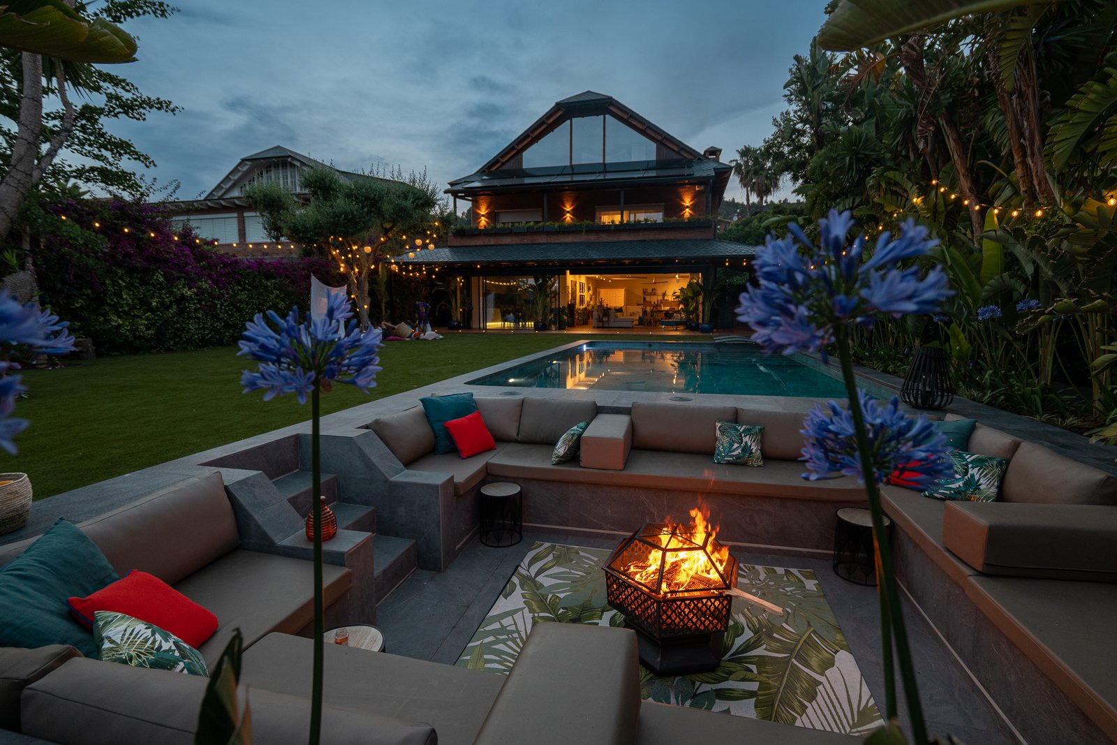 Zona chill-out hundida con fuego al atardecer